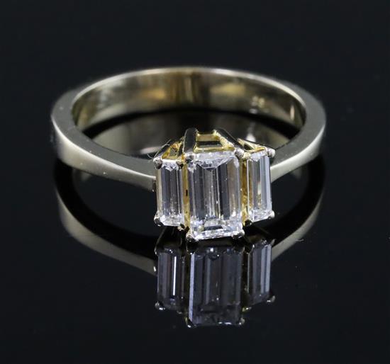 A modern 750 gold and graduated baguette cut diamond three stone ring, size Q/R.